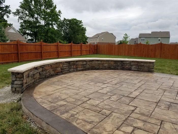 Stamped concrete patio with a curved seat wall
