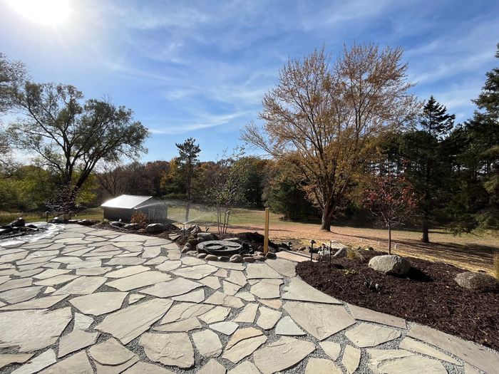 Wide flagstone patio with mulched beds in fall