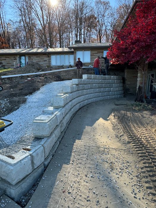 Tiered block wall with gravel behind it beside a drive, partly built