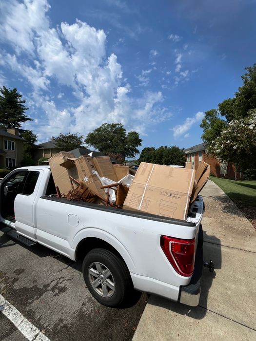 White pickup truck with its bed stacked high with cardboard boxes