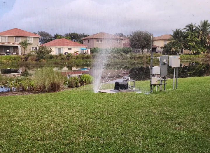 Irrigation: sprinkler heads running on a lakeside lawn