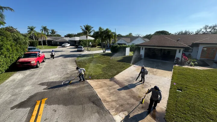 The crew cleaning up a driveway after a job