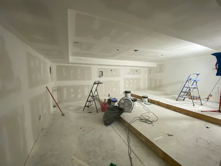 Large room with new drywall hung, taped and spackled