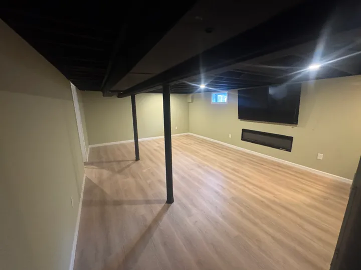 Finished basement with recessed lighting and a dark painted ceiling