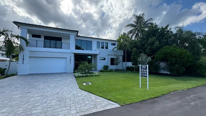 Pruning and tree trimming: shaped hedges and palms at a two-story home