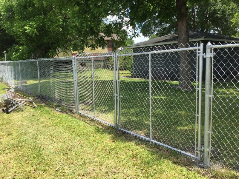 Galvanized chain link fence around a back yard