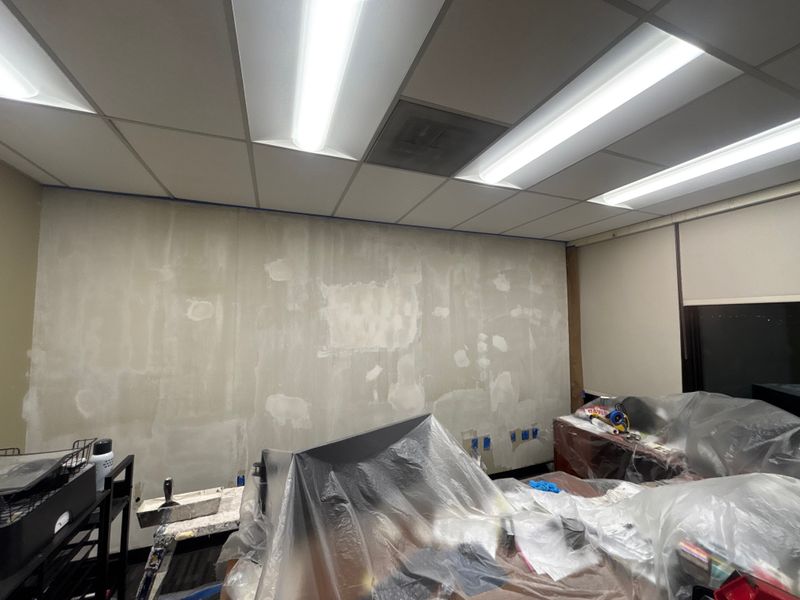 Office wall patched with plastic over the furniture