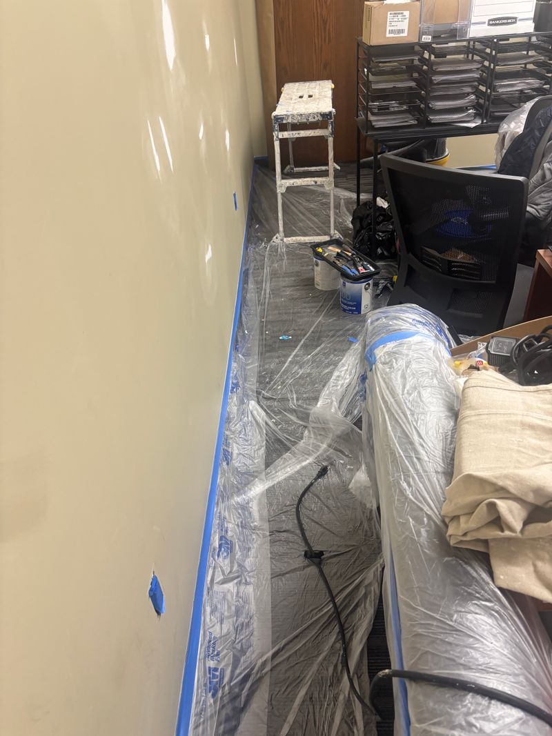 Plastic over furniture and tape at the baseboards