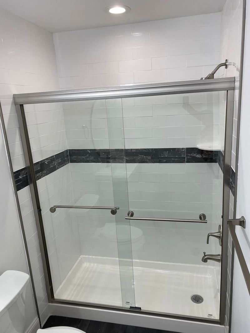 Tiled shower with a dark accent band