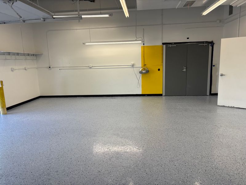 Flake epoxy floor with yellow wall and steel doors