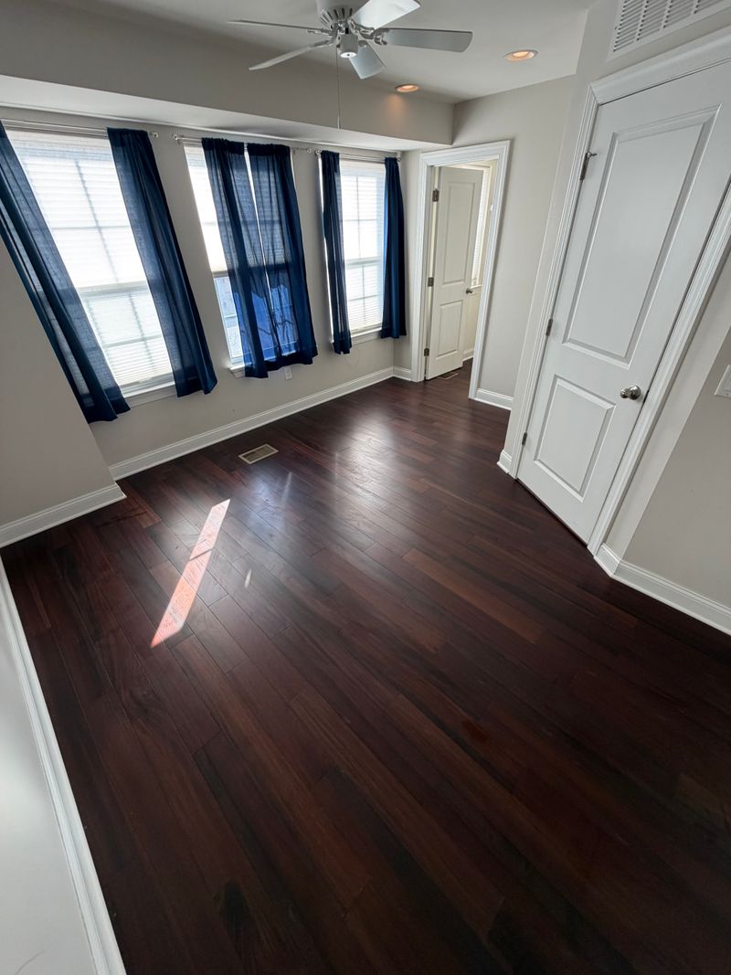 Dark hardwood floor in a bright bedroom