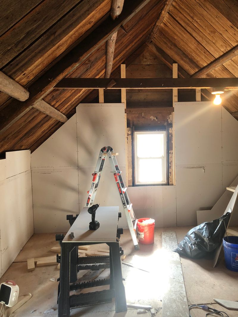 Attic with old roof boards and beams, new drywall going up