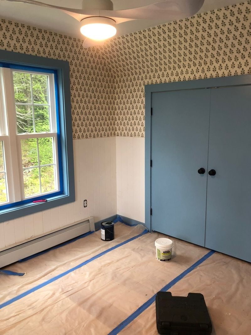 Blue painted doors and trim under fresh wallpaper
