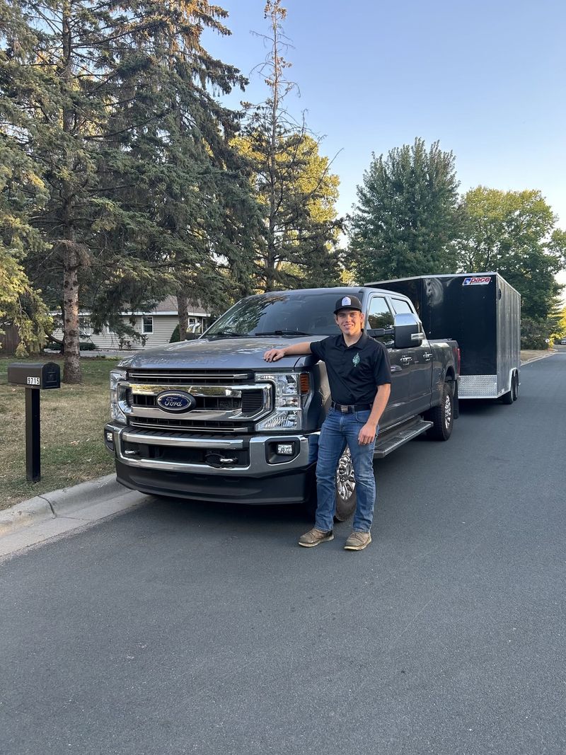 Andrew standing beside the AJS truck and trailer on a residential street