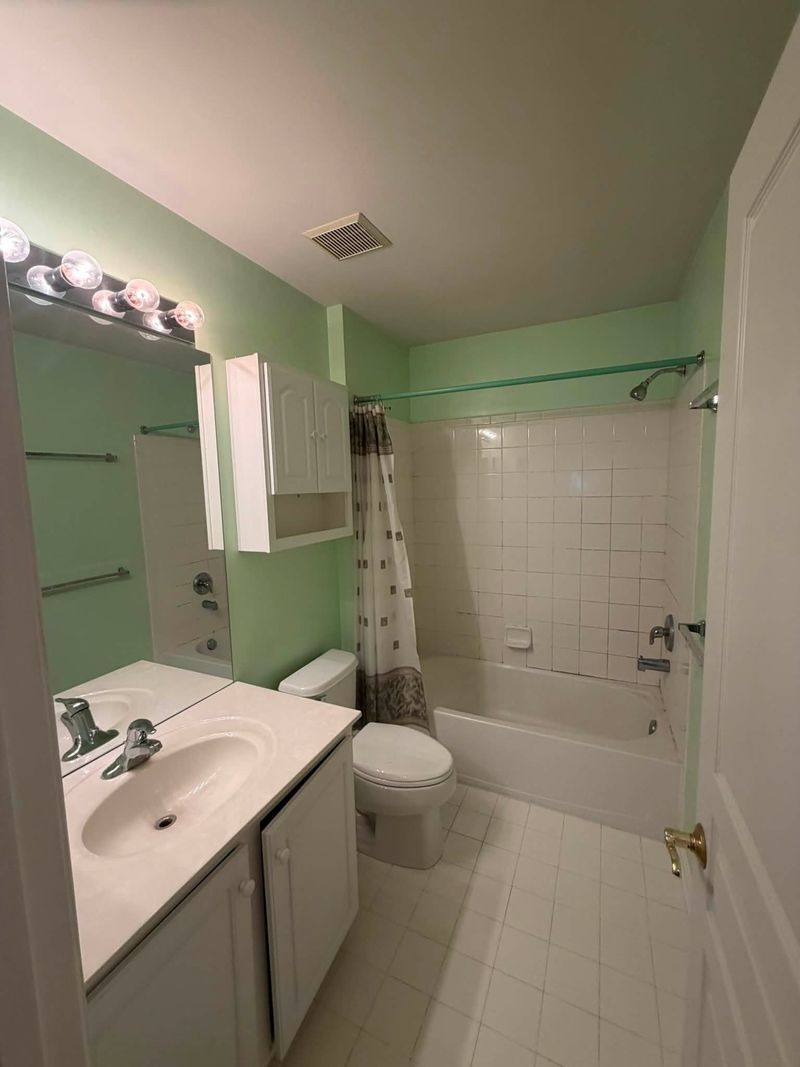 Updated bathroom with a white tile tub surround
