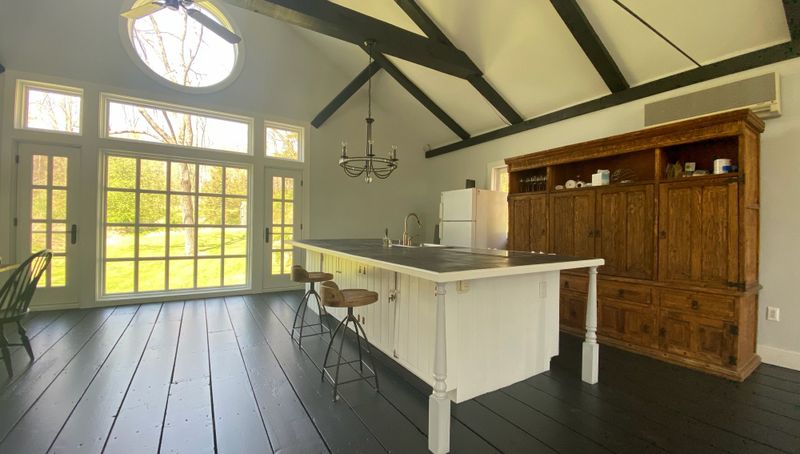 Barn kitchen island under painted trusses