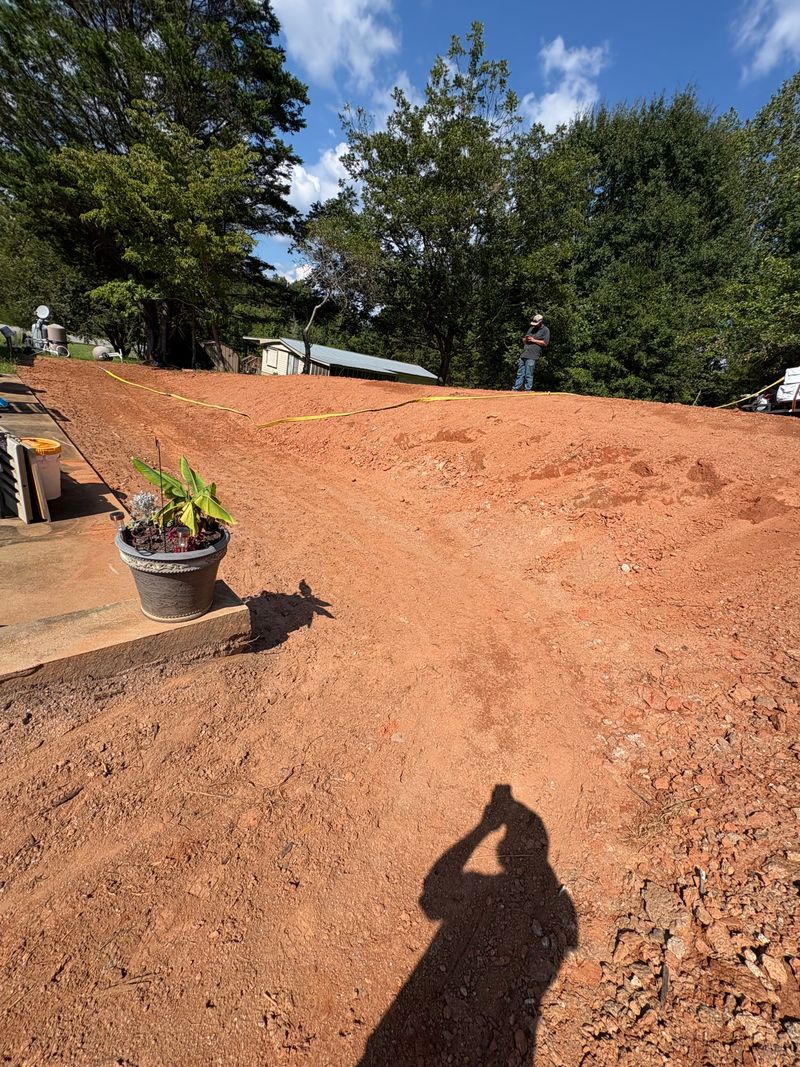 Bare graded yard prepared for seeding beside a house
