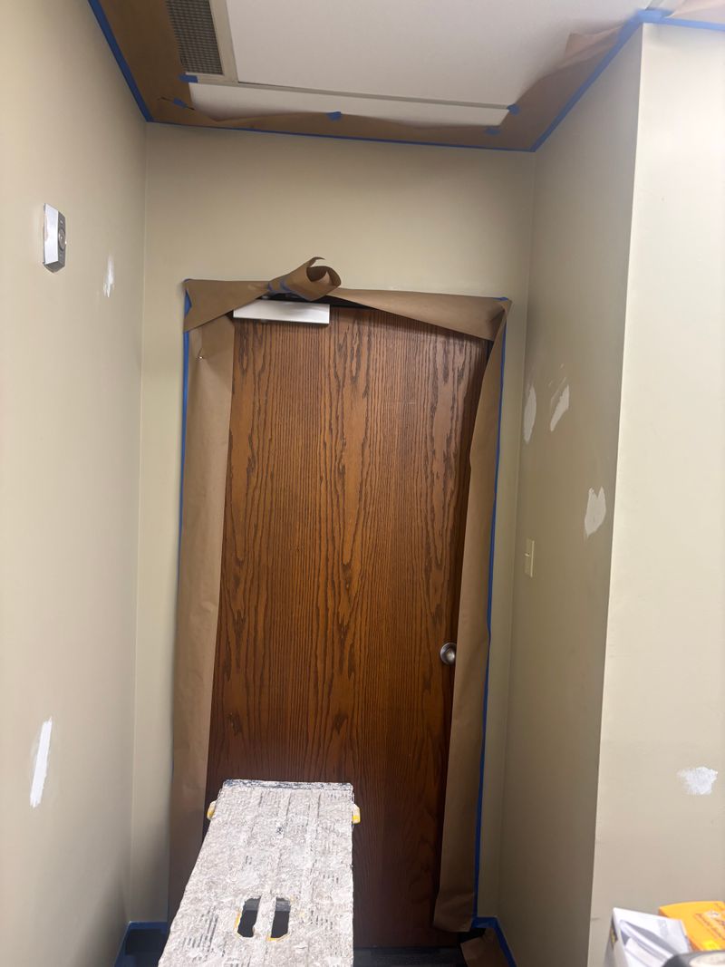 Doorway with new drywall patches and paper on the floor