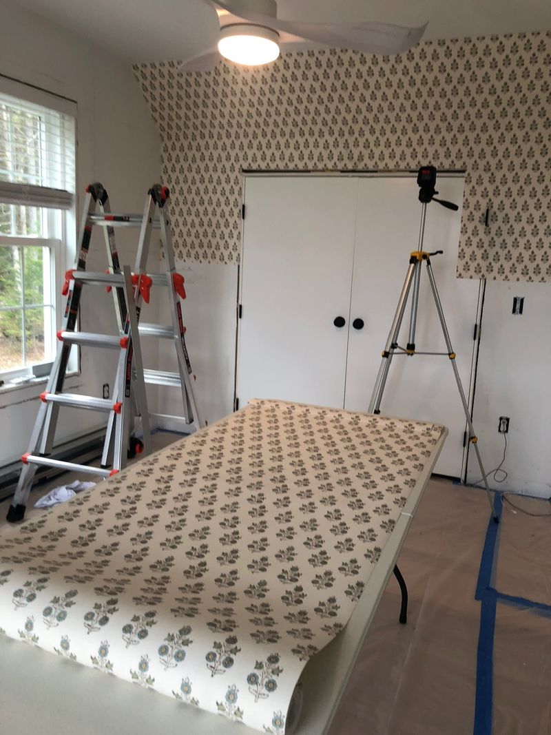 Wallpaper laid out on a pasting table in a room being papered