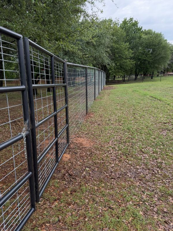 Welded steel pipe fence bordering an open pasture near Granbury, Texas