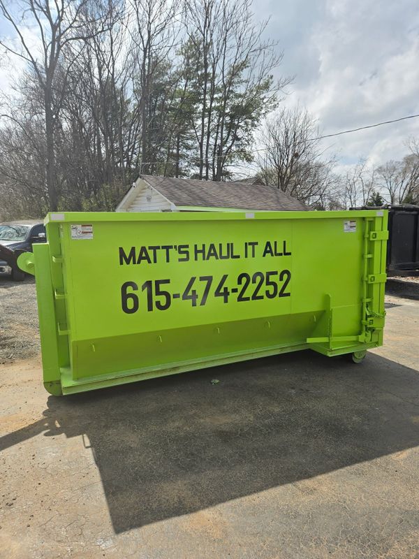 Green branded roll-off dumpster in a driveway