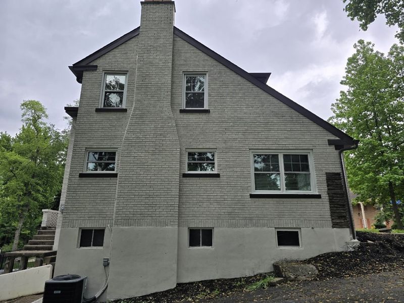 Side of a brick home with a soft gray limewashed finish