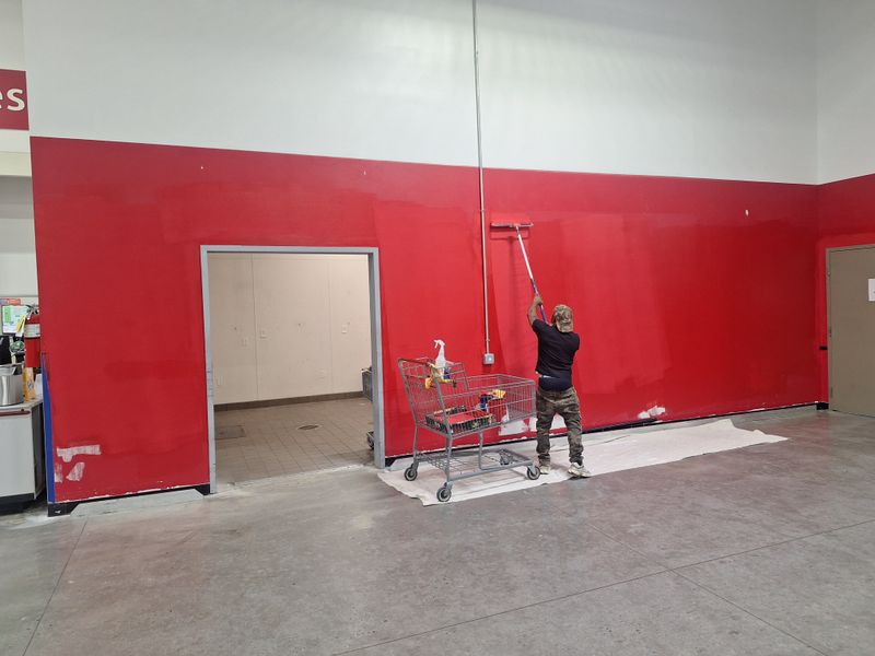 Painter rolling fresh paint across a large interior wall