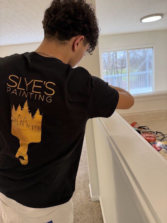 Slye's Painting crew member inspecting finished trim and walls in a home