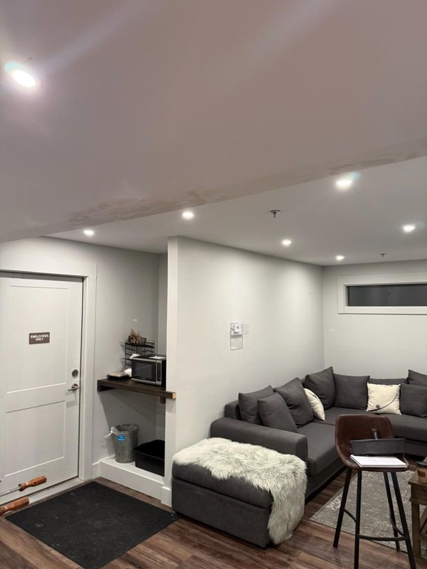 Finished room with a white door and casing, baseboard, a wood shelf in an alcove and recessed lights