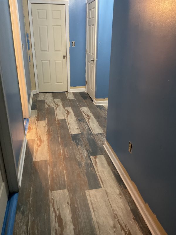 New wood look flooring laid down a hallway with freshly painted blue walls