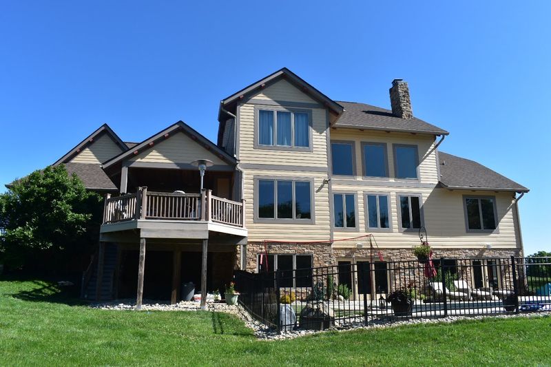 Tan lap siding and trim on a walkout home painted by Slye's Painting