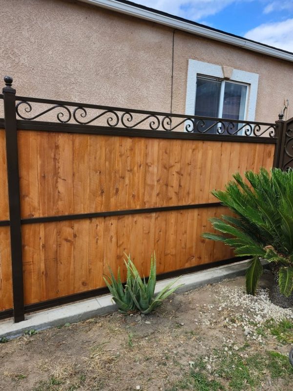 Cedar privacy fence with custom iron scroll topper by J&C Fencing