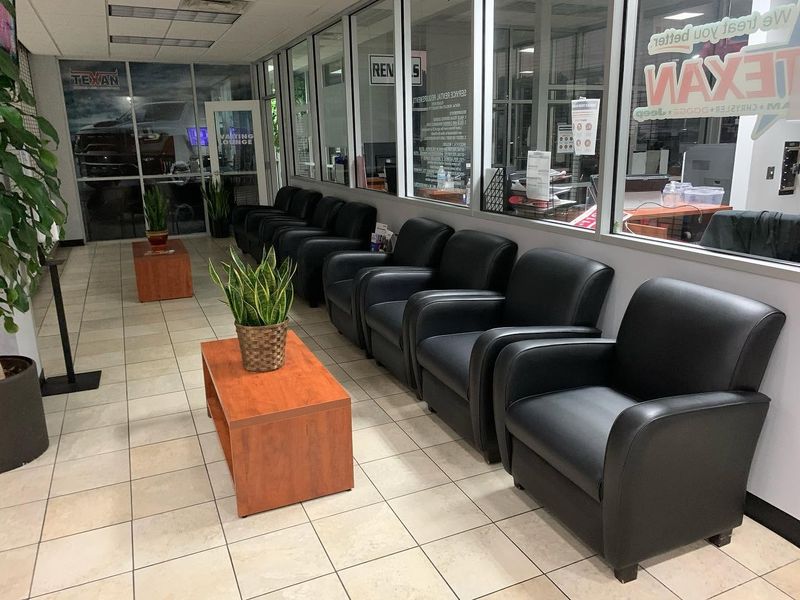 Waiting area with black leather armchairs and a wood coffee table in a commercial lobby