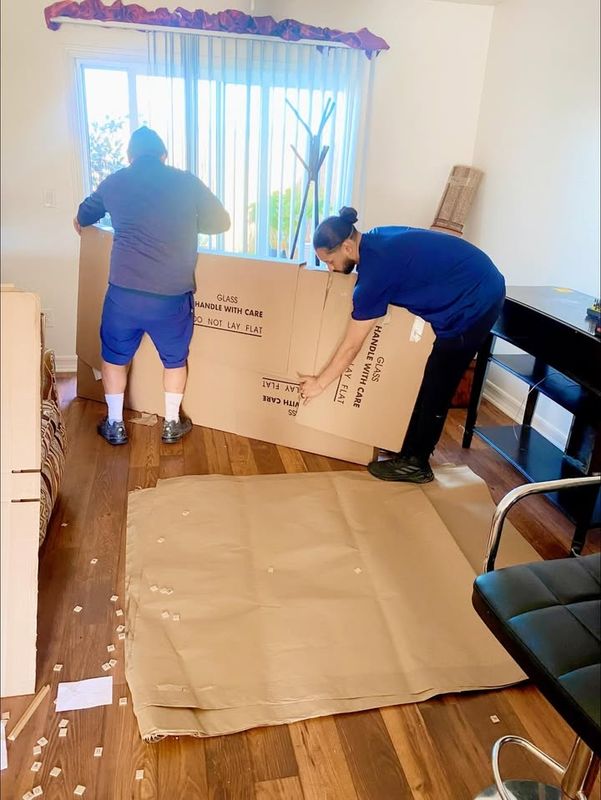 Mover packing boxes in a room before a move