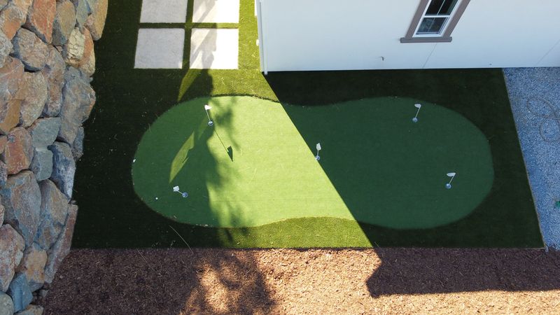 Elevate Your Backyard: A Stunning Golf Oasis with Natural Stone Accents
