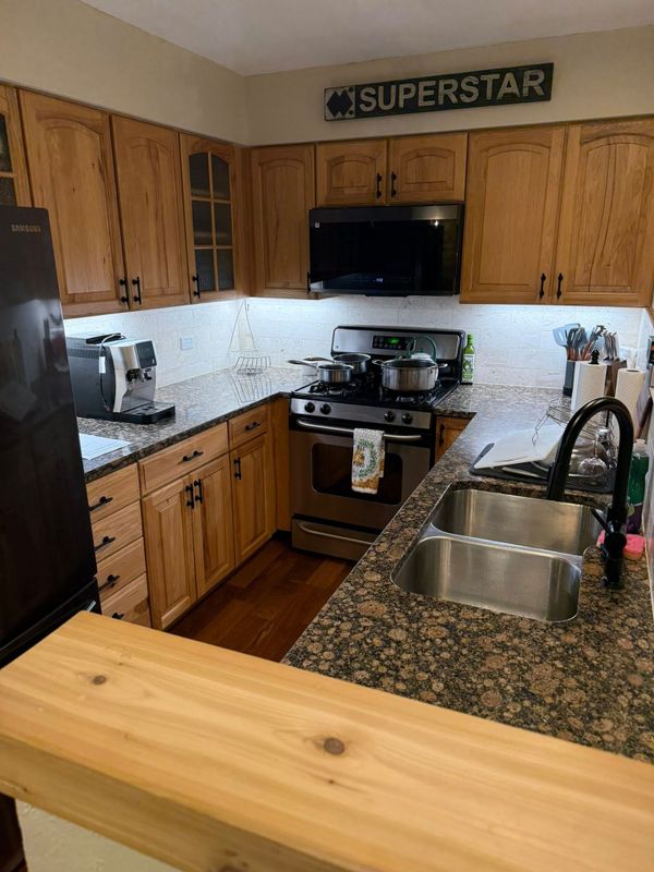 Tidy kitchen with granite counters and wood cabinets