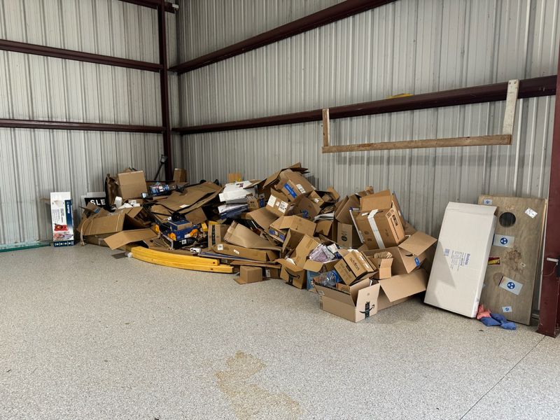 Warehouse bay packed with boxes and debris before the cleanout