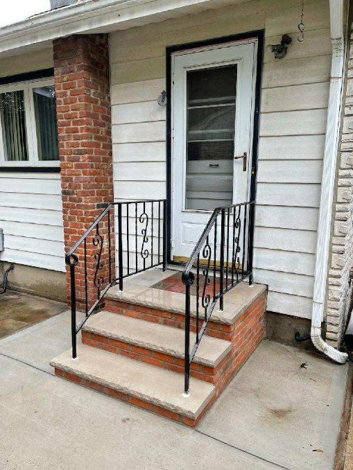 Elevate Your Entryway: Stunning Brick and Ironwork Magic by Dave's PRO Landscape Design & Masonry, LLC