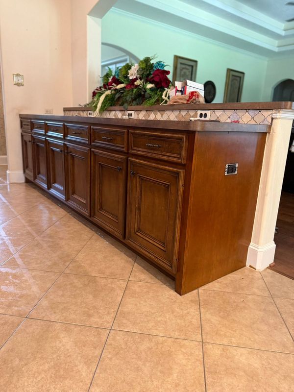 Run of dark wood raised-panel cabinets with drawers and doors, topped with a tile backsplash