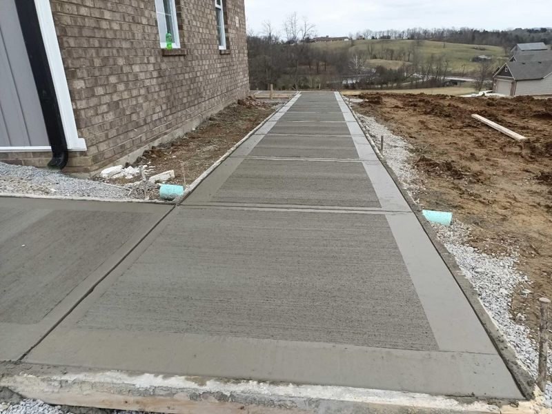 Poured concrete sidewalk along the side of a house