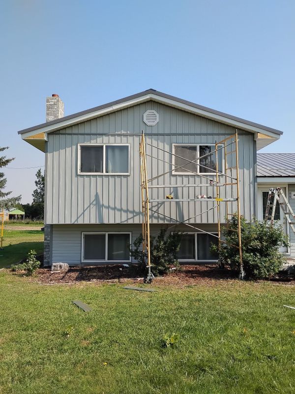 Split-level home with new vertical siding and scaffolding