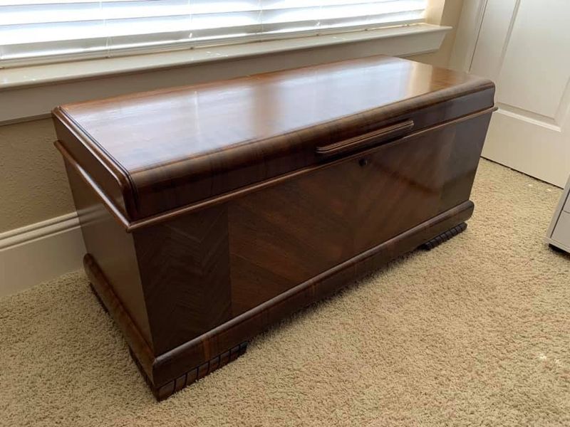 Wood cedar chest with a glossy finish under a window