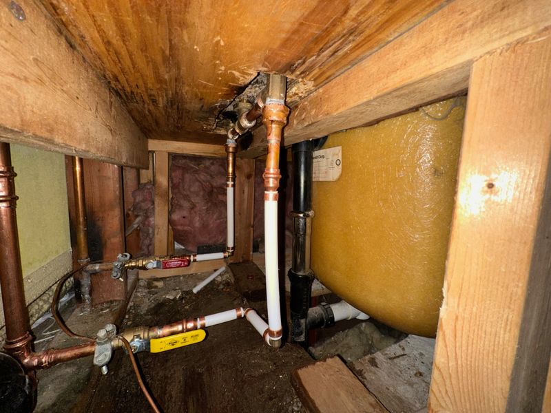 Copper and PEX water lines with shutoff valves in a crawlspace