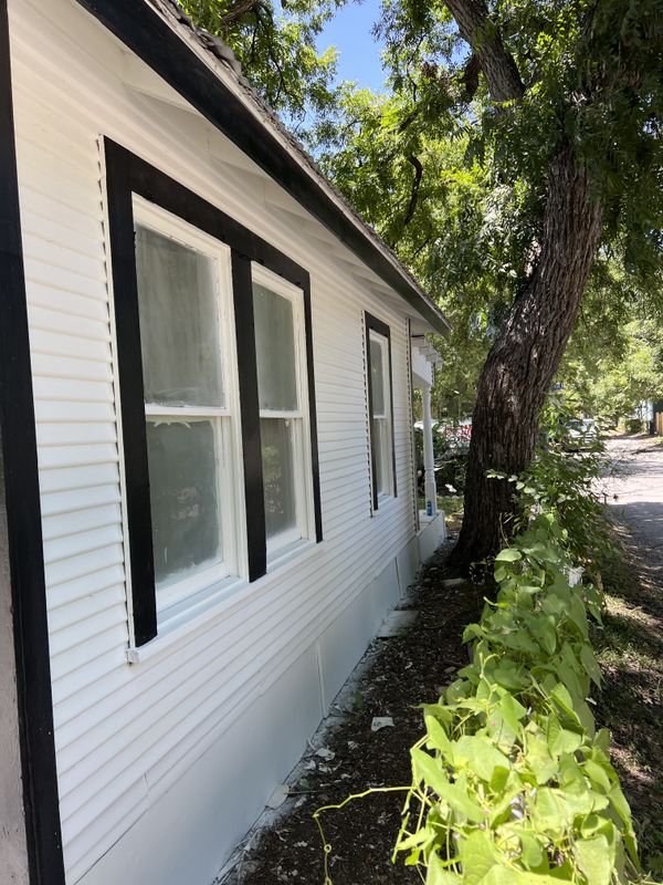 White lap siding with black window trim after an exterior repaint