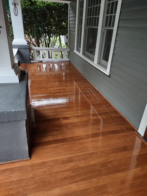 Glossy refinished oak floor in room with porch and windows, a hardwood floor refinishing project