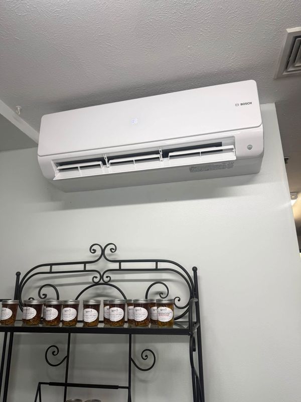 Wall-mounted ductless air conditioning unit in a room