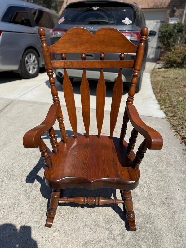 Wooden rocking chair with a carved spindle back and arms