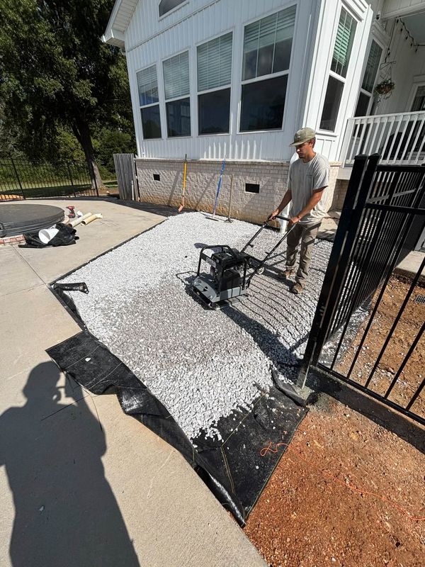 Compacting the gravel base for a new paver walkway