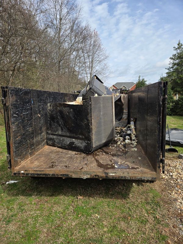 Black dumpster trailer full of broken hot tub panels