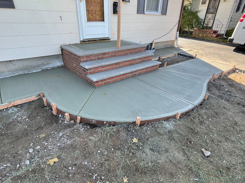 "Transforming Entrances: Elegant Concrete Walkway Installation by Buildsmore Contracting Inc"